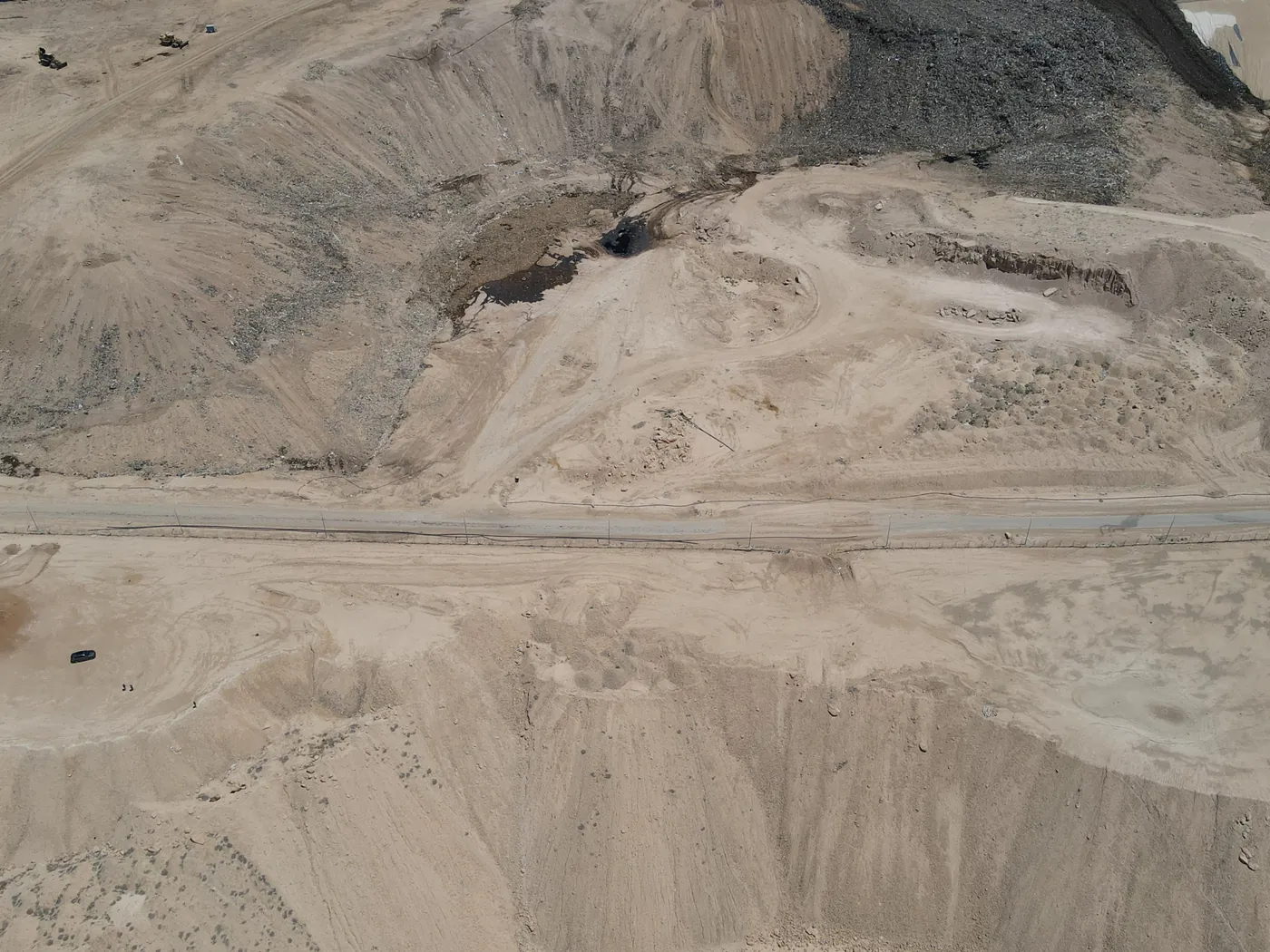 מדרונות עפר בשטח התא, ומעליהם דרך האתר ומשטח כהה של תא סמוך