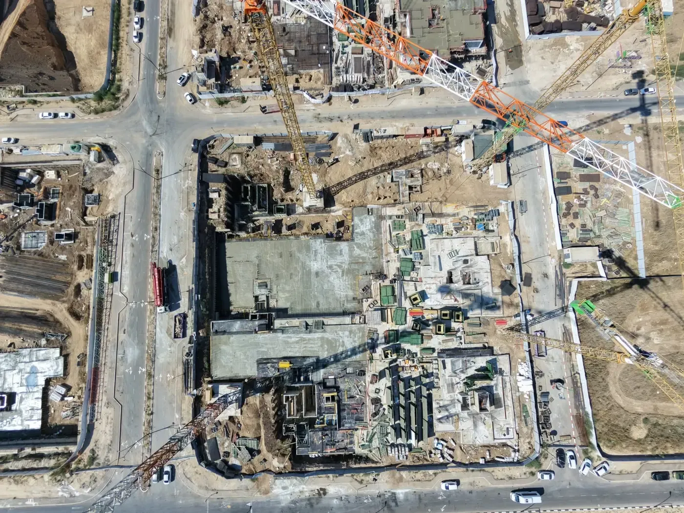 מבט אנכי רחב על אתר הבנייה ולצדו מגרשים סמוכים בשלבי ביצוע שונים בשכונת כרמי גת