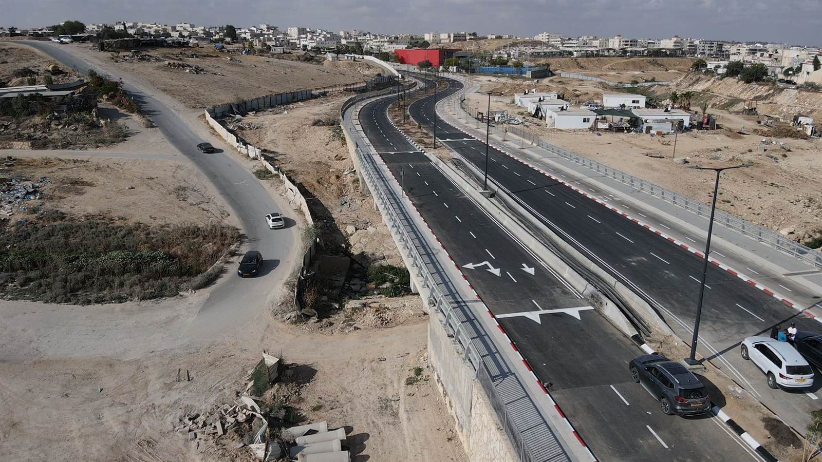 צילום אוויר של הגשר הגמור עם סימוני צבע, מעקות בטיחות ותאורה, ורכבים נוסעים עליו