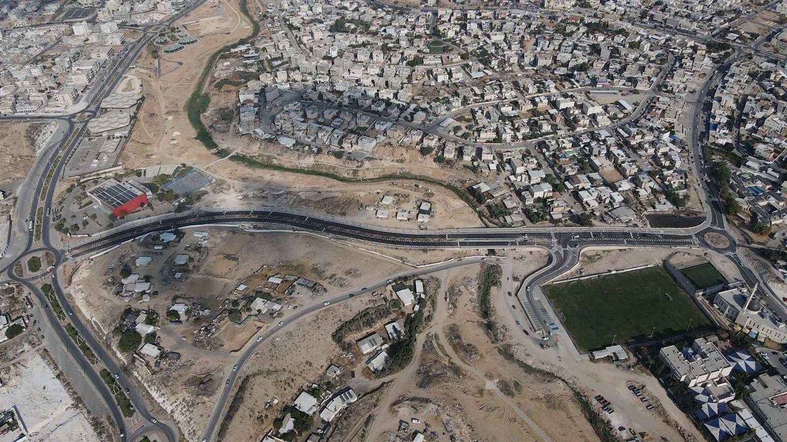 צילום אוויר רחב של רהט ובו תוואי הכביש החדש חוצה את העיר ומחבר בין השכונות