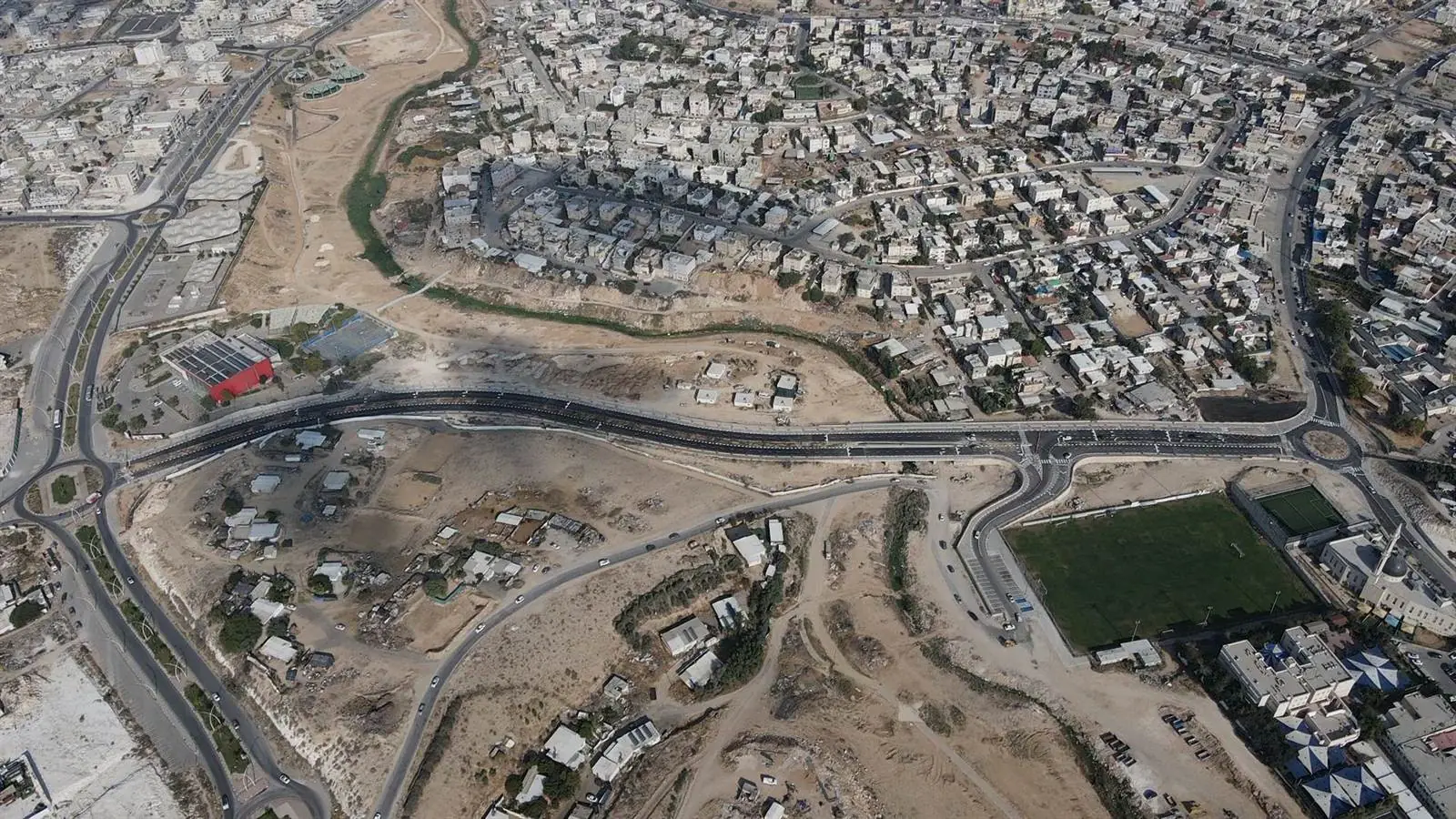 צילום אוויר רחב של רהט ובו תוואי הכביש החדש חוצה את העיר ומחבר בין השכונות