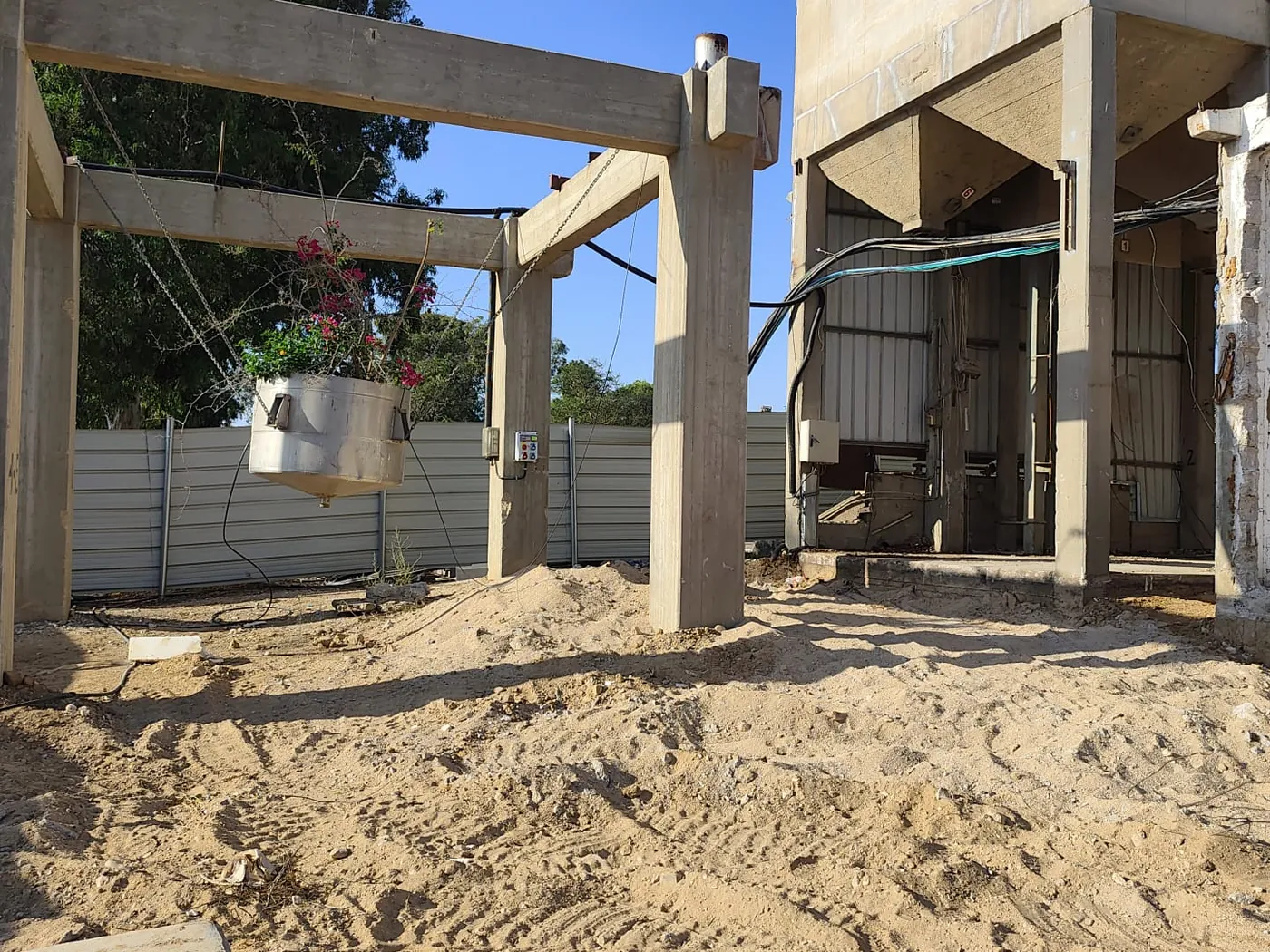 עמודי בטון ומסגרות קיימות בבסיס הסילו, בשולי אזור העבודה