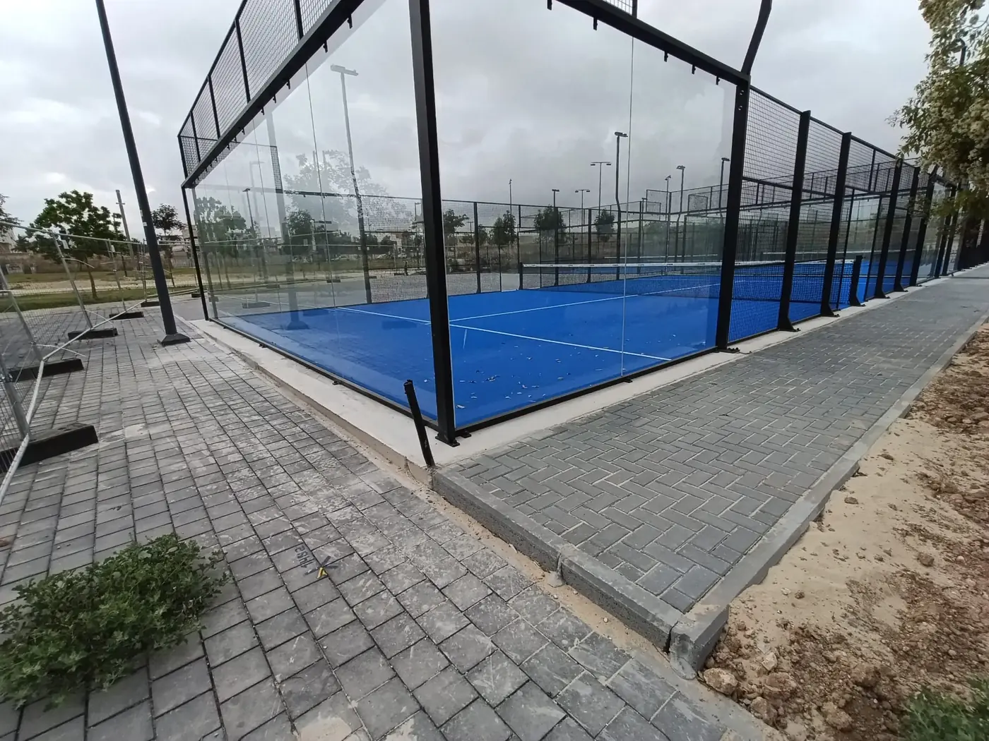 פינת מגרש פאדל ומפגש הריצוף עם שולי משטח הבטון והקרקע שסביבו